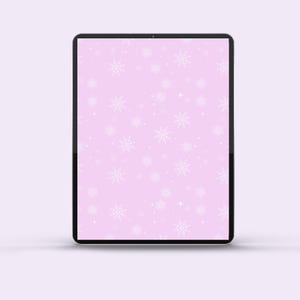 May include: A digital tablet shows a light pink screen with a repeating pattern of white snowflakes and small white dots. The tablet has a black bezel and is set against a soft, light purple background.