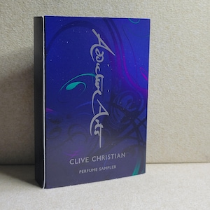 May include: A blue box with a silver inscription that reads "Clive Christian Perfume Sampler" and a silver cursive inscription that reads "Addictive Art".