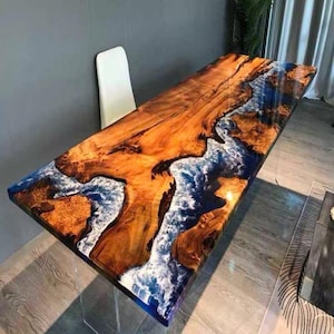 Mesa de jantar com tampo em resina epóxi com efeito rio e borda natural, inspirada na natureza e em madeira maciça, móvel com design moderno e luxuoso para decoração de interiores.