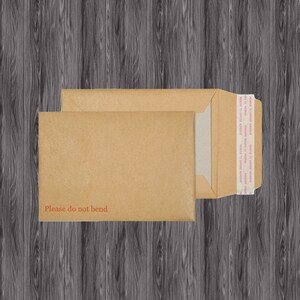 Puede incluir: Un sobre de papel marr&oacute;n con una etiqueta blanca y el texto "Please do not bend" impreso en &eacute;l. El sobre tiene una tira de cinta en el borde superior.