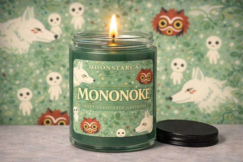 May include: A burning green candle in a glass jar, labelled "MONONOKE", with illustrations of wolves and forest spirits. The label also states the scent notes: "Sweet Grass, Sage, Lavender". The background has a repeating pattern of the same illustrations.