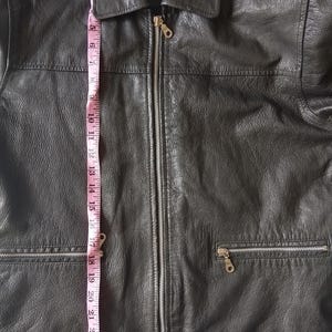 Pu&ograve; includere: Giacca in pelle nera con chiusura a zip e due tasche anteriori. La giacca &egrave; lunga circa 61 cm, misurata dalla parte superiore del colletto all'orlo inferiore. La giacca ha un collo.