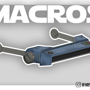 Peut inclure: Un appareil bleu et gris avec deux bras s'étendant sur les côtés. L'appareil possède un écran rectangulaire et quelques boutons sur le dessus. L'appareil est étiqueté "MACROS".