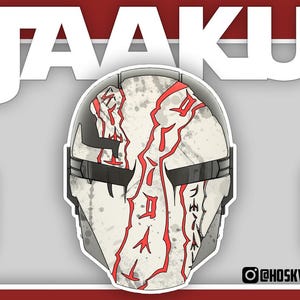 May include: A stylized illustration of a white and gray helmet with red accents and text. The word "JAAKU" is displayed in large white letters above the helmet. The design is set against a red background.