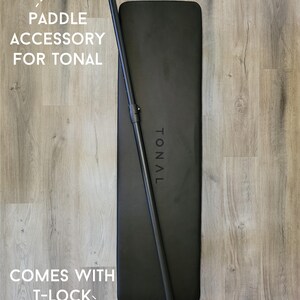 May include: Black paddle accessory for Tonal home gym equipment. The paddle comes with a T-lock adapter and is ready for use.