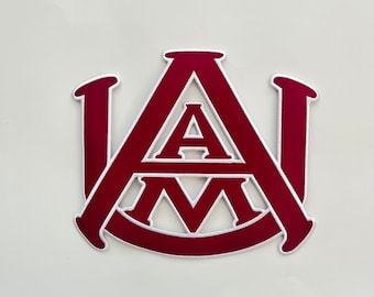 Op de afbeelding: Een geborduurde patch in maroon en wit met de letters "A&M" in een gestileerd lettertype.