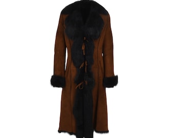 May include: A long brown shearling coat with a black fur collar and trim. The coat has a tie closure at the front.