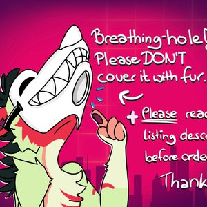 Op de afbeelding: Een cartoonillustratie van een groen en rood dier met een wit masker. Het dier wijst naar een tekstballon die zegt: "Breathing-hole! Please DON'T cover it with fur. + Please read the listing description before ordering. Thanks!"