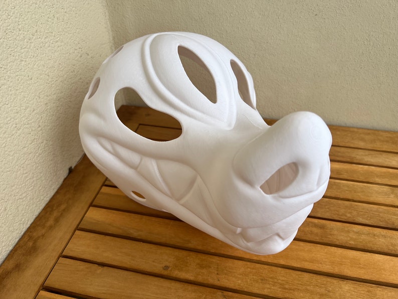 Op de afbeelding: Witte, ongeverfde vachtdiermasker met open oog- en neusgaten. Het masker is gemaakt van schuim en heeft een gedetailleerde snuit en tanden.