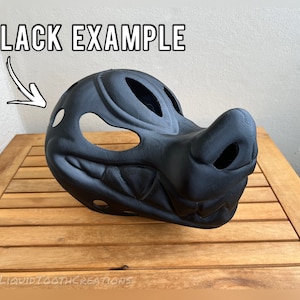 Op de afbeelding: Zwart voorbeeld van een 3D-geprint dierlijk masker. Het masker is van een wezen met een grote snuit en een tandenrij. Het masker heeft verschillende gaten voor ventilatie en zicht.