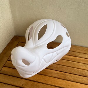 Op de afbeelding: Witte, ongeverfde vachtdiermasker met grote ooggaten en een gedetailleerde snuit.