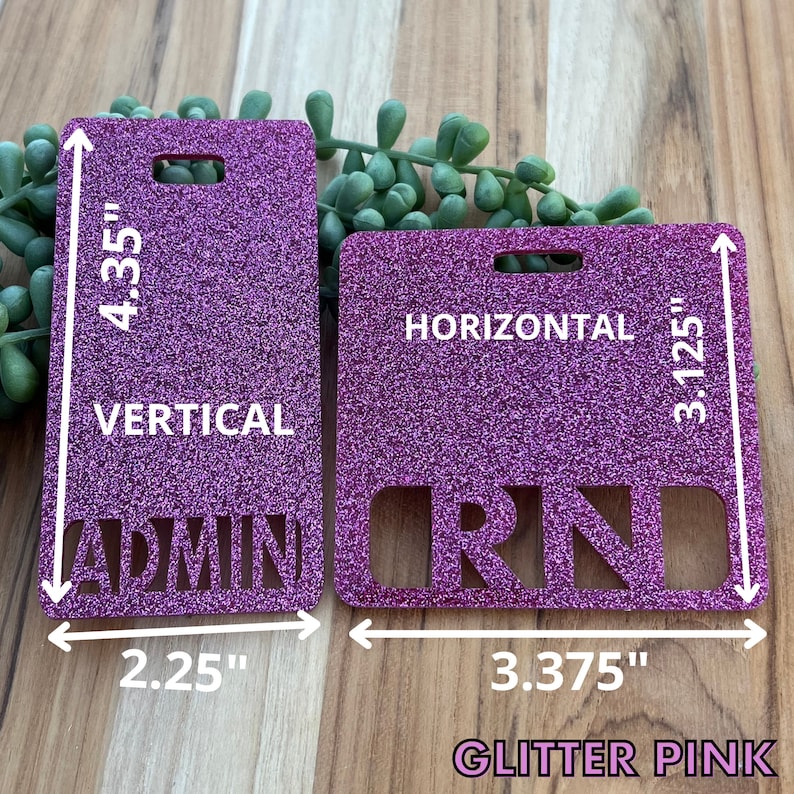 May include: Two pink glitter name tags with a hole for a lanyard. The left tag is 4.35 inches tall and 2.25 inches wide and says "ADMIN" in white letters. The right tag is 3.125 inches tall and 3.375 inches wide and says "RN" in white letters. Both tags have the words "HORIZONTAL" and "VERTICAL" printed on them.