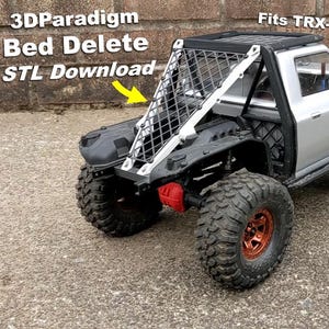 Könnte beinhalten: Ein silbernes und schwarzes TRX-4 Sport Modell-Truck mit großen, grobstolligen Reifen und einem Überrollkäfig. Der Text "3DParadigm Bed Delete STL Download" ist auf der Seite des Trucks zu sehen.