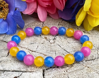Può includere: Un braccialetto fatto di perline gialle, blu e rosa. Le perline sono rotonde e lisce e sono infilate su un cordoncino elastico trasparente.