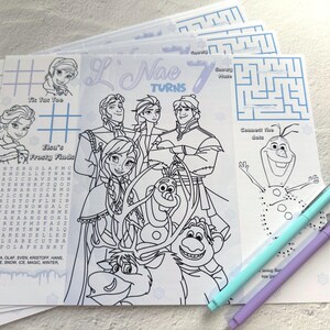 Op de afbeelding: Een stapel Frozen-thema activiteitenvellen met Elsa, Anna, Olaf en andere personages. Elke vel bevat kleurplaten, doolhoven, woordzoekers en verbind-de-stippen activiteiten. Twee pennen, één turquoise en één paars, zijn zichtbaar.