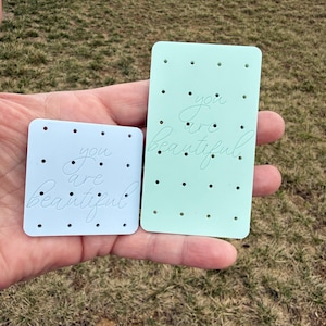 May include: A handmade wooden sign with the text "Welcome to our home" in a handwritten style. The sign is painted white with black lettering and a distressed finish, measuring approximately 12 inches wide.