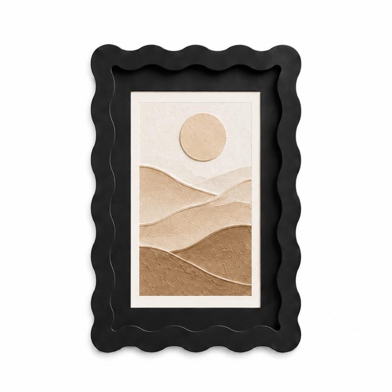 May include: A rectangular wall art piece featuring a textured landscape with rolling hills in shades of beige and brown under a circular sun, encased in a thick black frame with a wavy, scalloped outer edge and a smooth inner border.