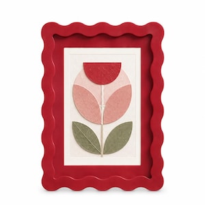 May include: A rectangular wall art piece featuring a red wavy frame surrounding a textured white background. The central artwork displays a stylized flower composed of a red semi-circle, two pink oval petals, and two green leaves.