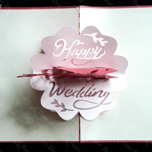 Pode incluir: Um cart&atilde;o pop-up rosa e branco com as palavras "Happy Wedding" em uma fonte decorativa.