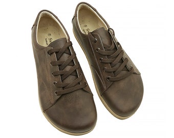 May include: A pair of brown leather lace-up shoes with a rounded toe. The shoes have a light brown sole and are made of a textured leather.