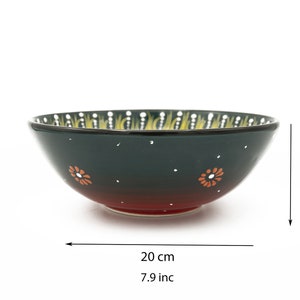 K&ouml;nnte beinhalten: Eine gr&uuml;ne und rote Keramiksch&uuml;ssel mit einem gelben und wei&szlig;en Blumenmuster. Die Sch&uuml;ssel ist 20 cm breit und 7 cm hoch.