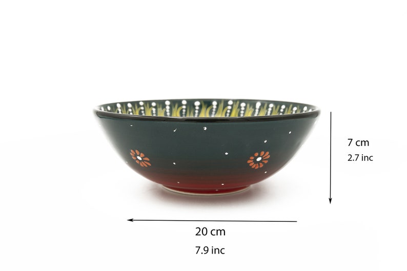 K&ouml;nnte beinhalten: Eine gr&uuml;ne und rote Keramiksch&uuml;ssel mit einem gelben und wei&szlig;en Blumenmuster. Die Sch&uuml;ssel ist 20 cm breit und 7 cm hoch.