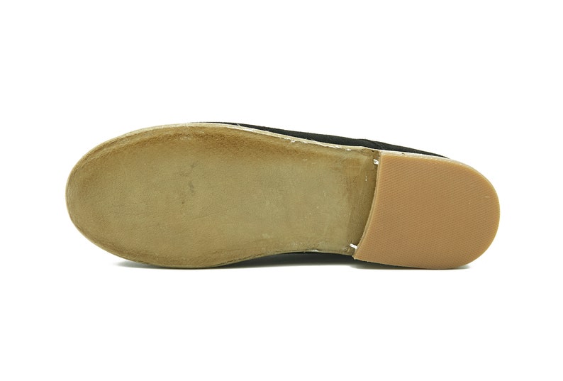 May include: The bottom of a black suede shoe with a brown leather sole.