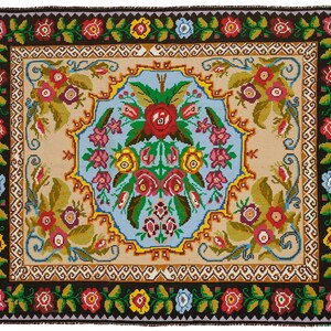 May include: A rectangular rug with a black border and a central design featuring a light blue and beige background. The rug is adorned with a floral pattern in red, pink, yellow, and blue, creating a vibrant and decorative piece.