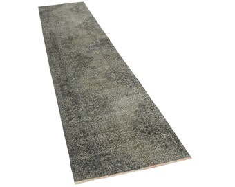 May include: A rectangular, distressed-look rug in shades of gray and beige. The rug has a textured surface and a long, narrow shape, suitable for a hallway or entryway. The rug's design gives it a vintage appearance.