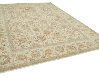 May include: A large, cream-colored rug with a floral pattern in shades of brown and orange. The rug has a border with a more intricate design.