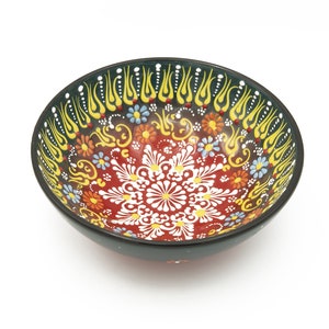 K&ouml;nnte beinhalten: Eine rote und schwarze Keramiksch&uuml;ssel mit einem bunten floralen und geometrischen Design. Die Sch&uuml;ssel hat einen schwarzen Rand und eine wei&szlig;e Mitte mit einem floralen Muster.