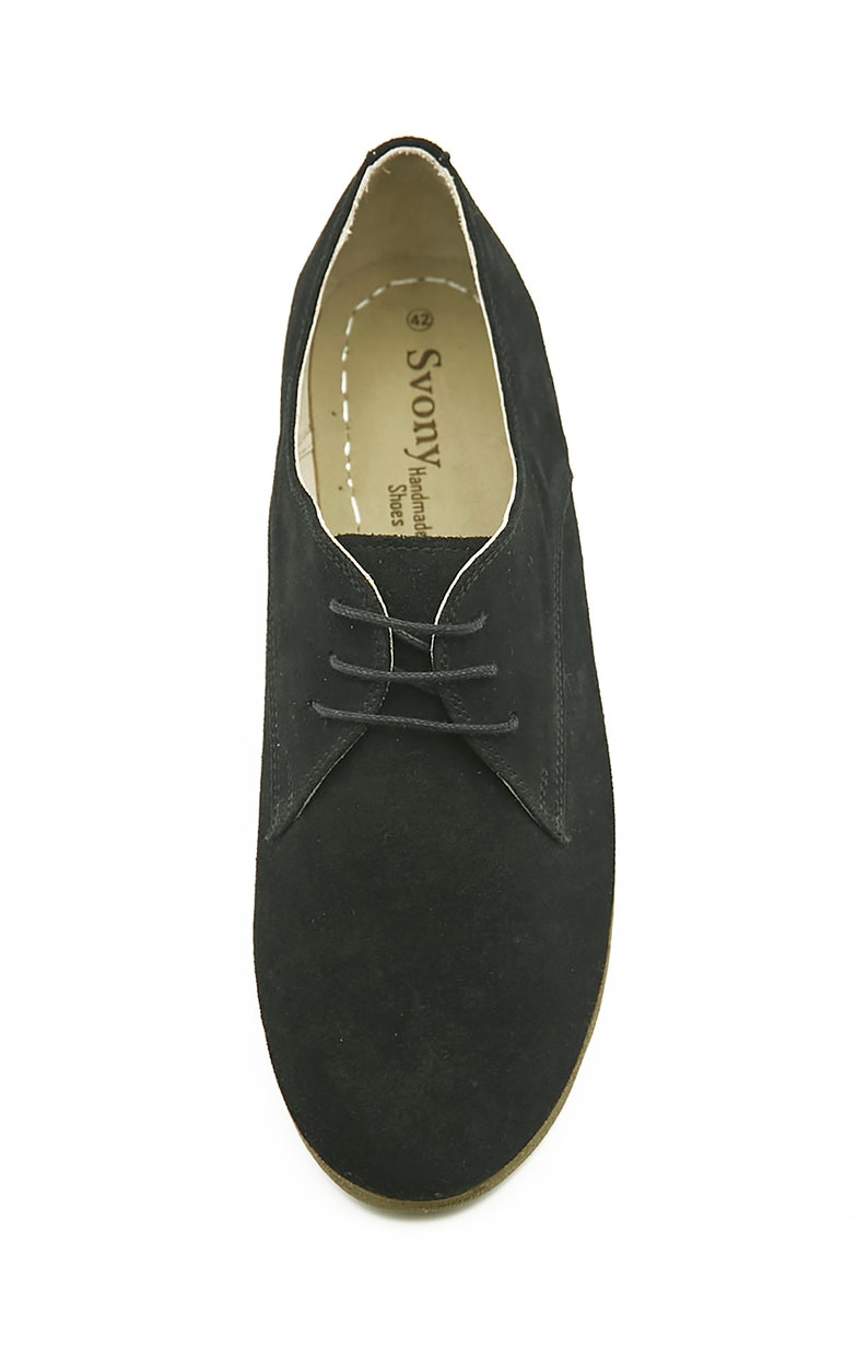 May include: Black suede lace-up shoes with a brown sole. The shoes have a white label inside that reads "SvonY Handmade Shoes".