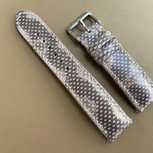 May include: Two light brown leather watch straps with a textured pattern. The straps have silver buckles.