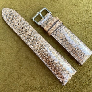 May include: Two watch straps made of brown leather with a textured pattern. The straps are both 20mm wide and have a buckle closure.