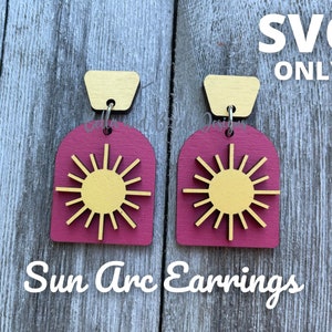 May include: A pair of wooden Sun Arc Earrings. The earrings feature a gold sun design on a magenta arch shape, with a gold rectangular top. The text "SVG ONLY" is in the upper right corner. The text "Sun Arc Earrings" is at the bottom.