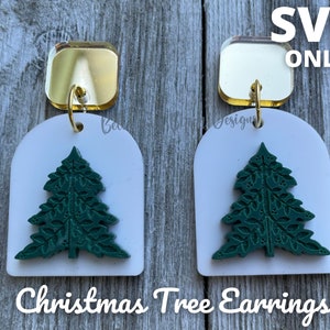May include: A pair of Christmas Tree Earrings. Each earring features a gold square top, a white arched base, and a green Christmas tree design. The text "SVG ONLY" is at the top, and "Christmas Tree Earrings" is at the bottom.
