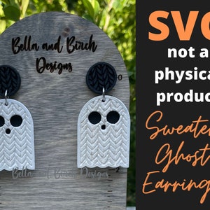 May include: A pair of white ghost-shaped earrings with a black knit texture. The earrings are displayed on a wooden board with a ruler. The text "Bella and Birch Designs" is visible on the board. The text "SVG not a physical product Sweater Ghost Earrings" is visible in the background.