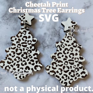 May include: A pair of white wooden Christmas tree earrings with a cheetah print design and a white star on top. The earrings are for crafting and are not a physical product.