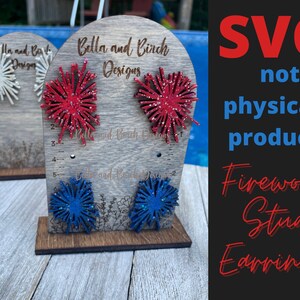 May include: SVG cut file design for firework stud earrings. The design features red, white, and blue firework shapes. The text "Bella and Birch Designs" is visible on the wooden display stand.