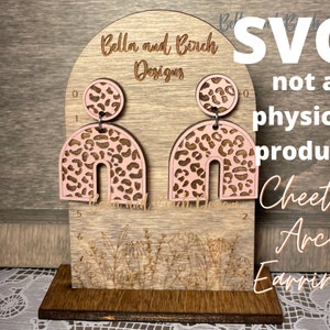 May include: A digital download SVG file for creating cheetah print arch earrings. The design features a pink arch with a cheetah print pattern. The text "SVG not a physical product Cheetah Arch Earrings" is visible in the image.