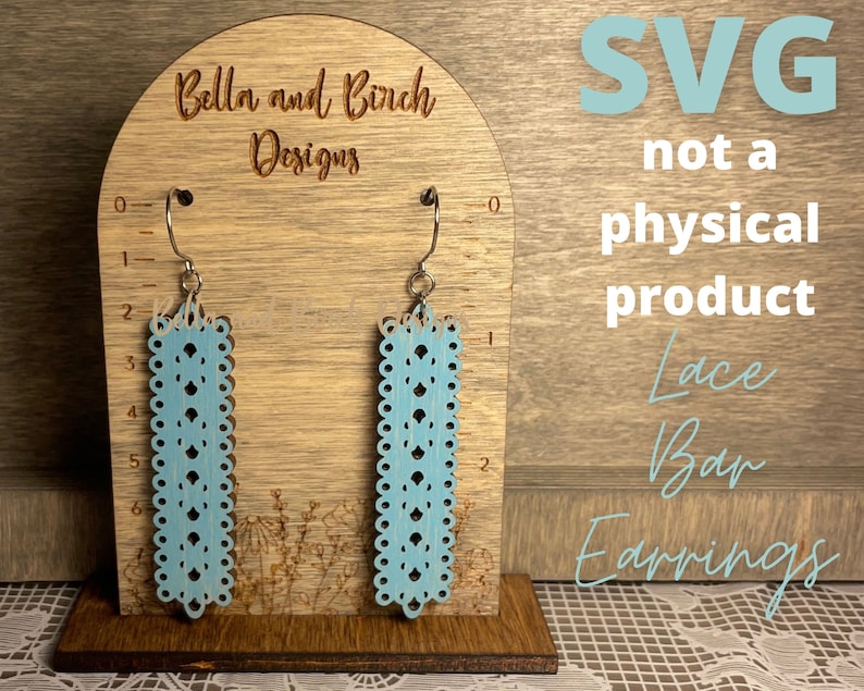 May include: A digital download SVG file for a pair of blue lace bar earrings. The earrings are shown on a wooden display stand with a ruler for size reference. The text "SVG not a physical product Lace Bar Earrings" is also visible in the image.