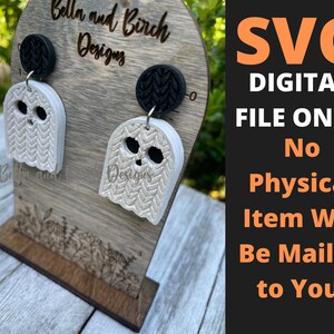 May include: A pair of white ghost-shaped earrings with a textured surface, displayed on a wooden stand. The earrings are for sale as a digital SVG file only. The text "SVG DIGITAL FILE ONLY No Physical Item Will Be Mailed to You." is displayed on a black and orange background.