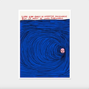 May include: Art print with the text "LIFE CAN ONLY BE UNDERSTOOD BACKWARDS BUT IT MUST BE LIVED FORWARDS" above a blue swirling design. A small pink face is in the center of the design.