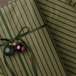 Gestreiftes Weihnachtspapier. Grüne Geschenkpapierrolle für die Feiertage. Klassisches gestreiftes Geschenkpapier für die Saison. Vintage-Geschenkpapier.