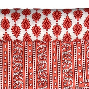 May include: A coral pink cotton bed sheet with a white and red geometric pattern. The sheet is rolled up and has a floral pattern on the reverse side.