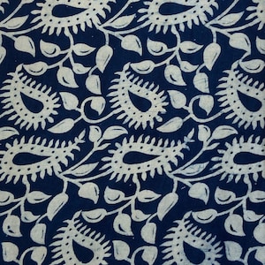 May include: A dark blue fabric with a white paisley pattern. The fabric has a traditional Indian design.