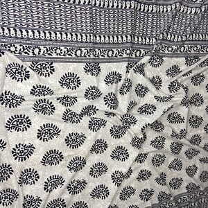 Peut inclure: Tissu blanc avec un motif paisley noir. Le tissu est pli&eacute; et a une bordure avec un motif noir et blanc plus petit.