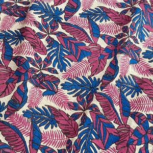 May include: A fabric with a repeating pattern of blue and purple leaves on a cream background.