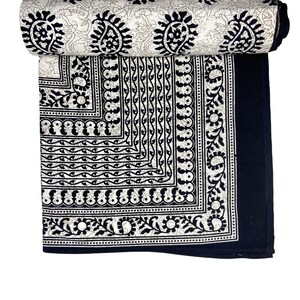 Peut inclure: Tissu en coton noir et blanc avec un motif paisley. Le tissu est roul&eacute; et a une bordure de motifs complexes.