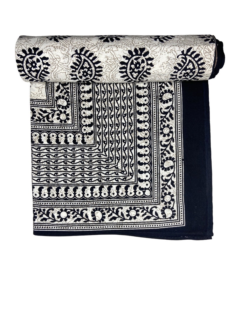 Peut inclure: Tissu en coton noir et blanc avec un motif paisley. Le tissu est roul&eacute; et a une bordure de motifs complexes.